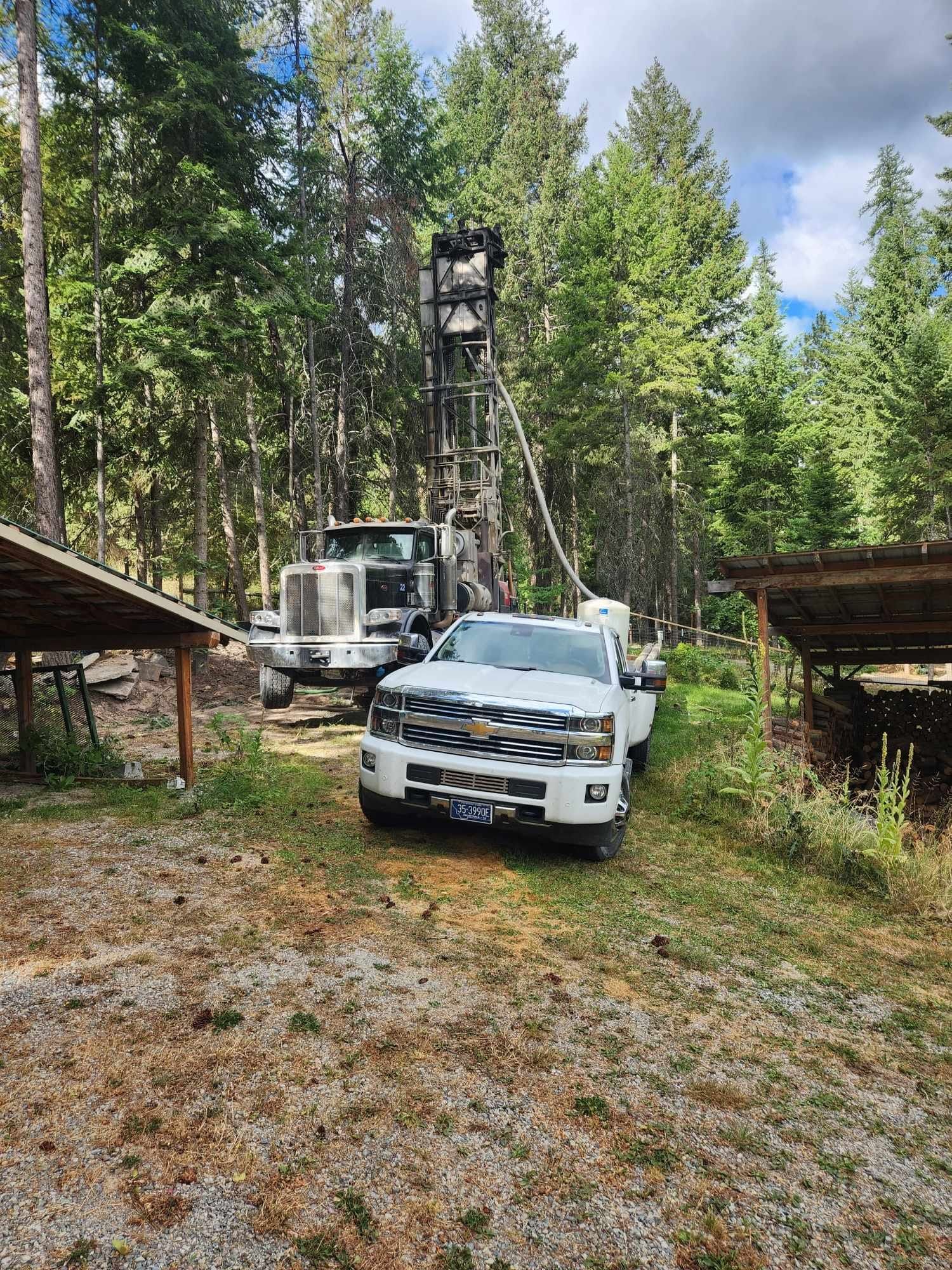 A White Truck Is Parked In Front Of A Drilling Rig | Thompson Falls, MT | North Star Drilling Inc.