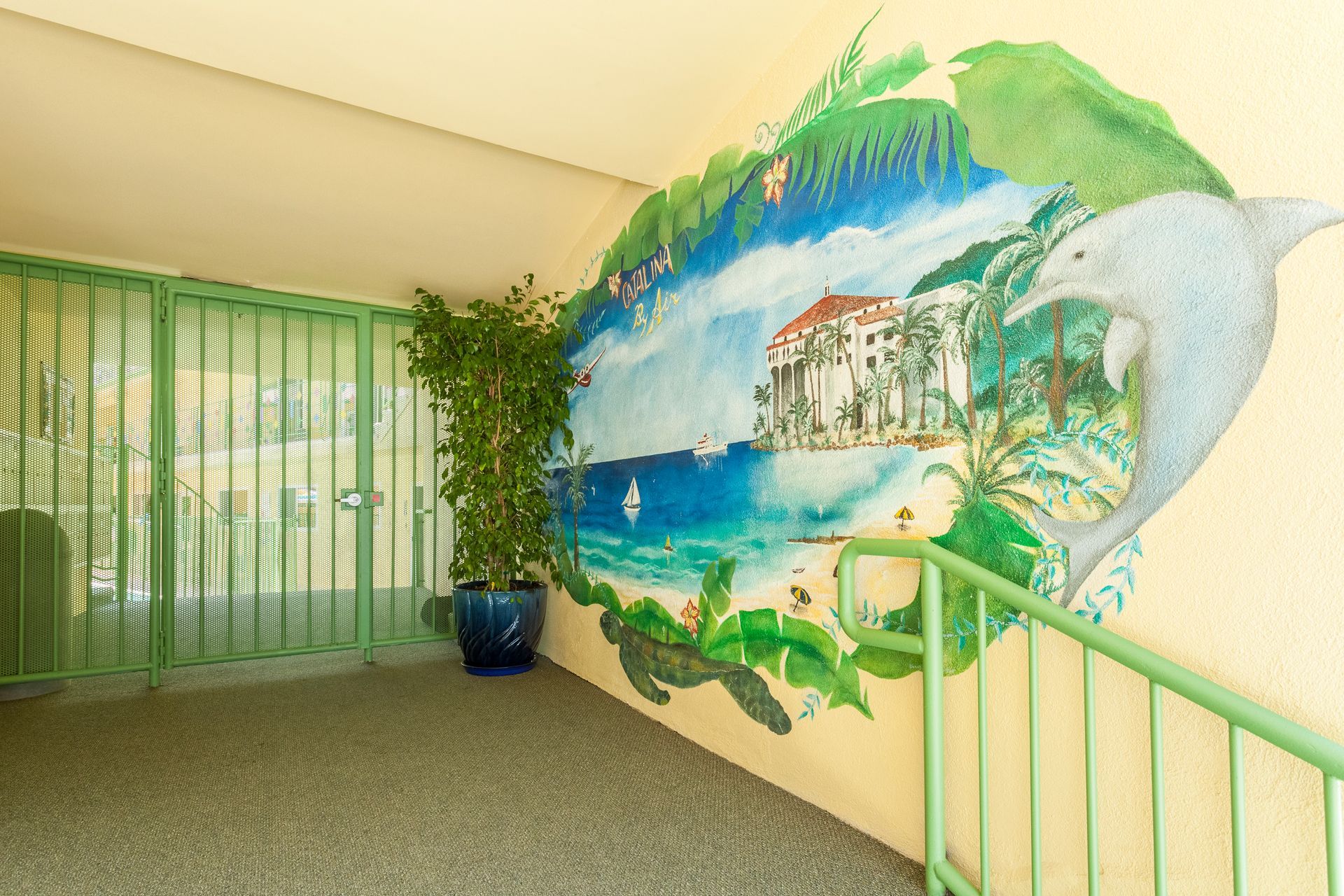 A staircase with a painting of a dolphin on the wall