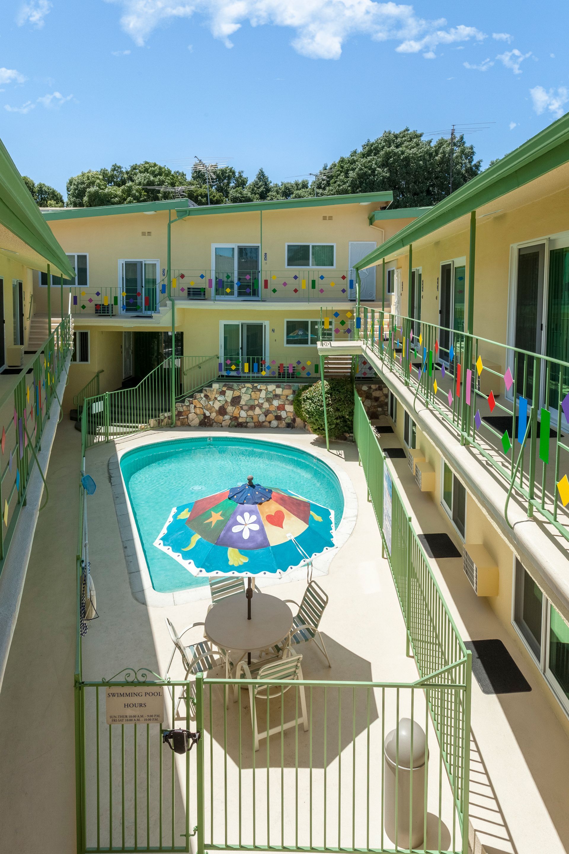 An aerial view of a hotel with a swimming pool and umbrellas