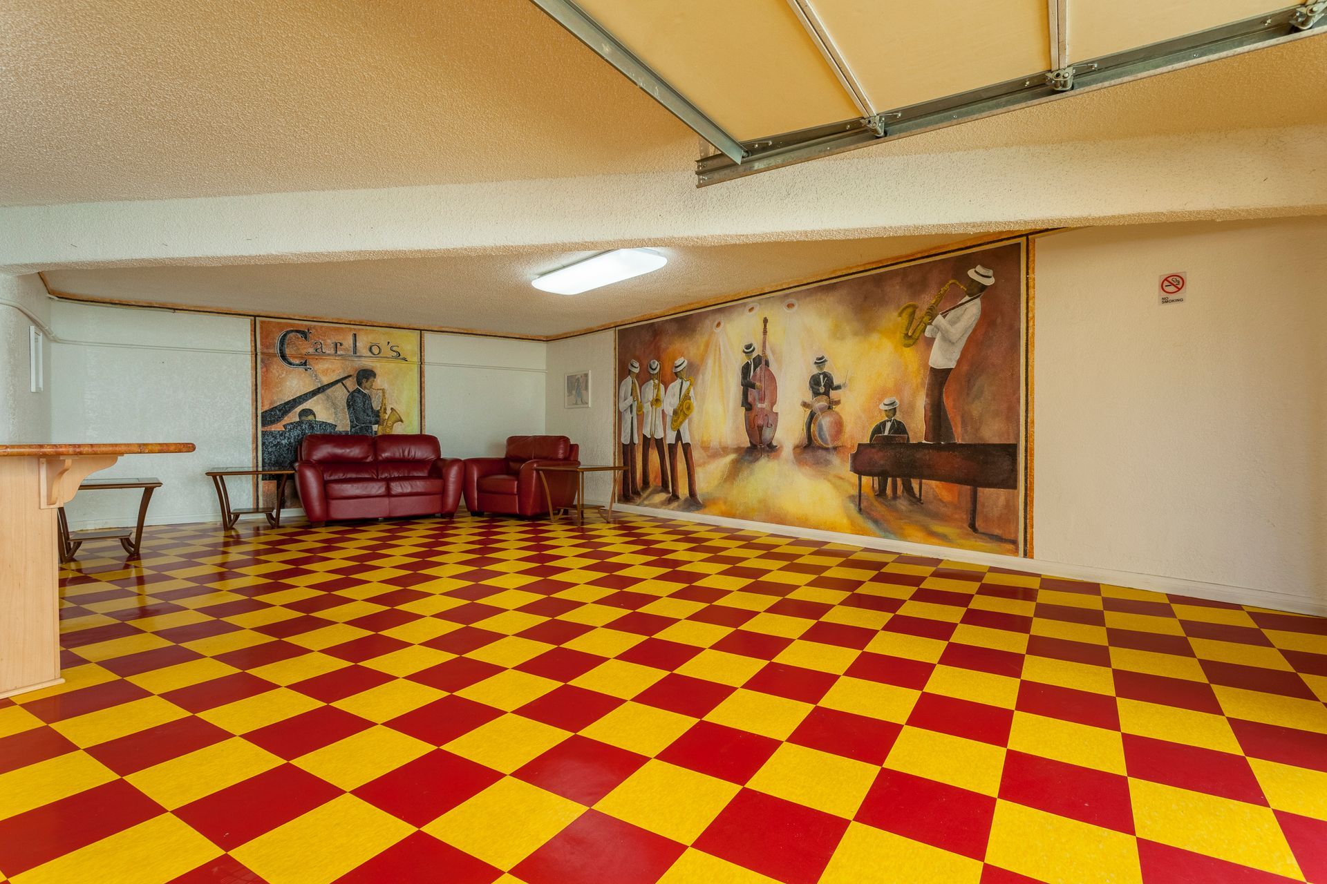 A room with a red and yellow checkered floor and a painting on the wall.