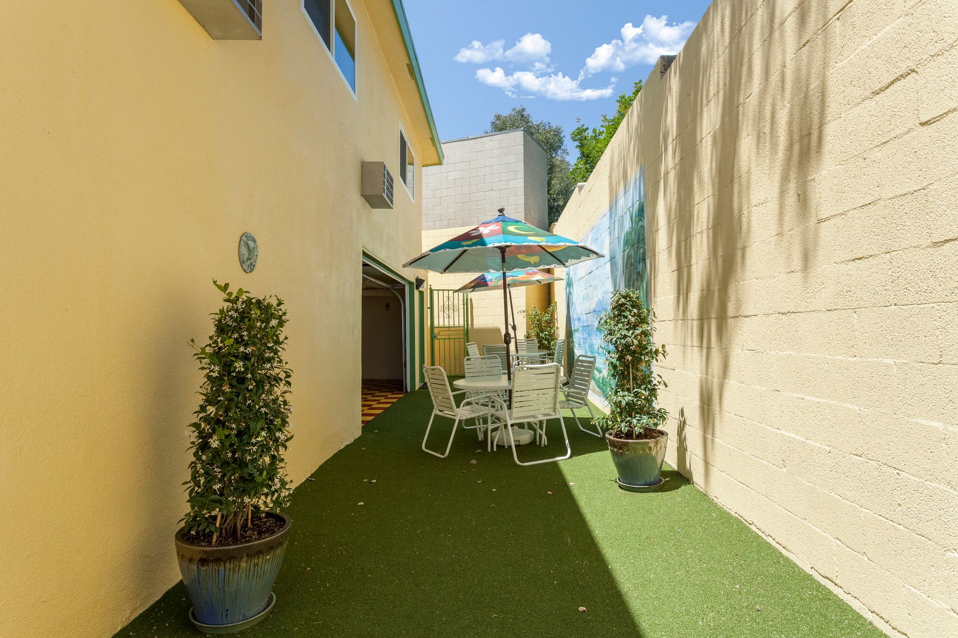 A patio with a table and chairs and an umbrella