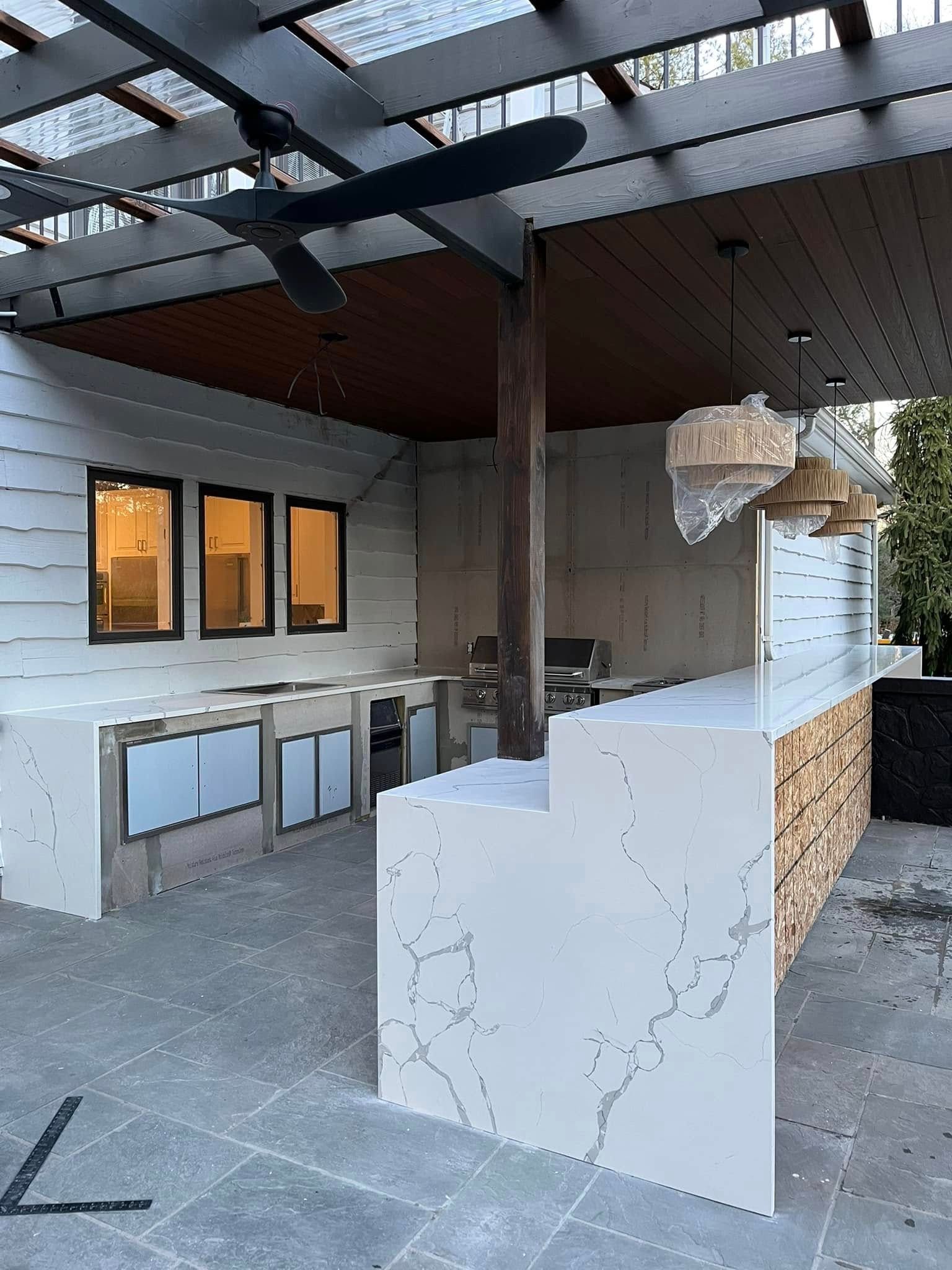 Woman in straw hat smiles, holding wine glass near a lake.