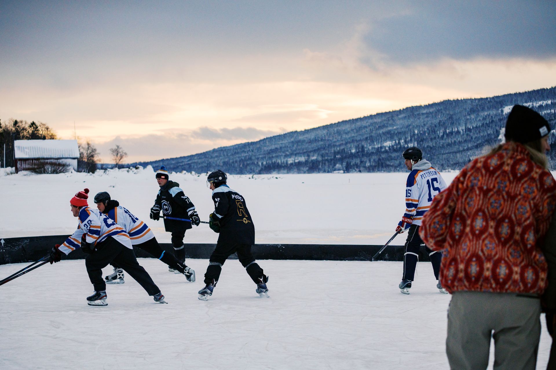 Pipolätkä-pelaaja vauhdissa Åre-järven jäällä. Pond hockey -turnauksessa varusteiksi riittävät luistimet, maila ja kypärä.