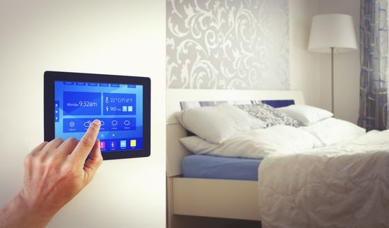 una mano che digita su uno schermo per regolare la temperatura della camera da letto