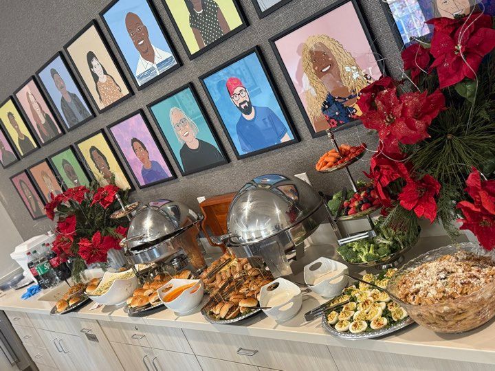 A buffet table with a bunch of food and pictures on the wall
