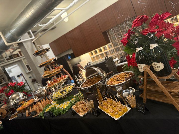 A buffet table with a lot of food and a bottle of champagne.