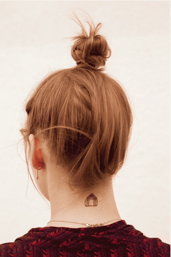 Woman with bun hairstyle and neck tattoo, facing away from viewer.