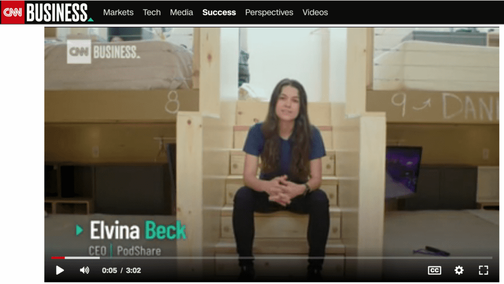 Elvina Beck, CEO of PadShare, sits on wooden stairs in a minimalist setting.