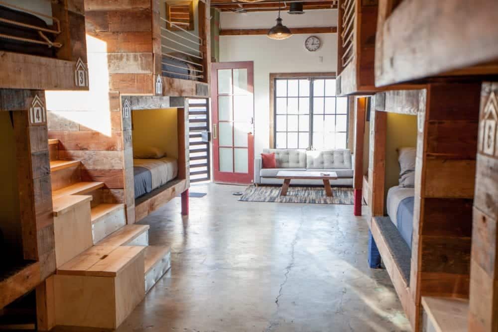 Bunk beds in a hostel room, rustic decor, bright, sunlight.
