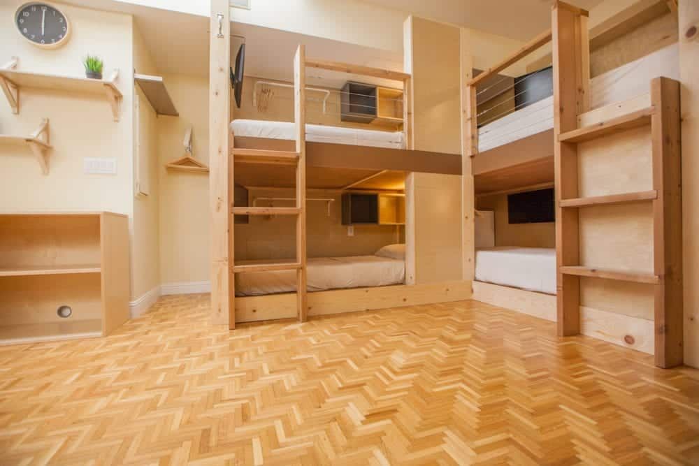 Bunk beds in a room with light wood floors. Two bunk bed sets are visible, with ladders and shelves.
