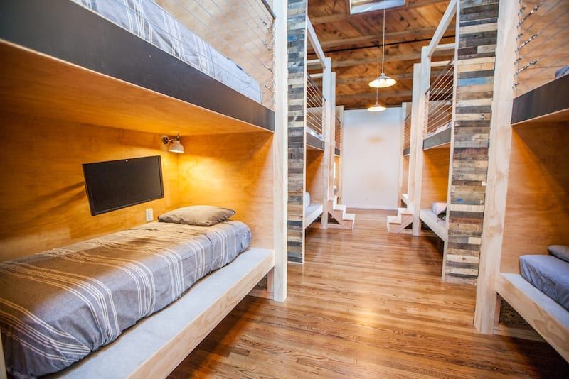 Bunk beds in a hostel room with wooden floors and walls.