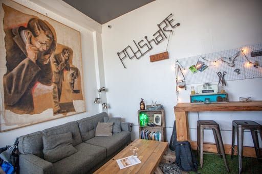 Cozy interior with a gray couch, wooden table, artwork, and a 
