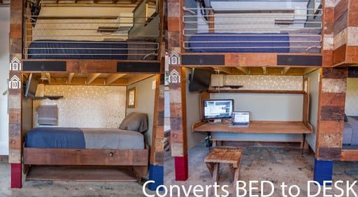 Modular bunk beds: lower beds convert to desks. Wooden frames with blue and red accents.