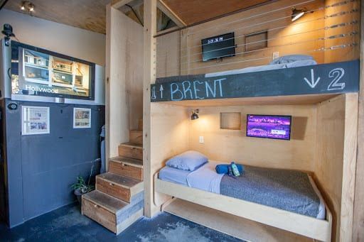 Bunk bed unit with a TV at each level. A staircase leads to the top bunk labeled "Brent".