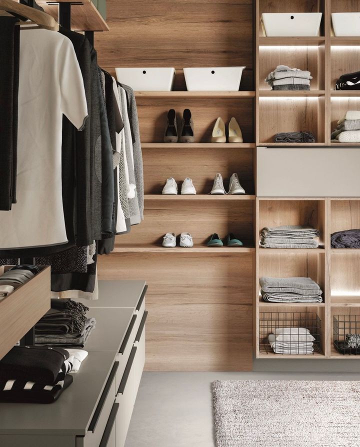 Walk-in closet with wooden shelves, hanging clothes, and organized storage.