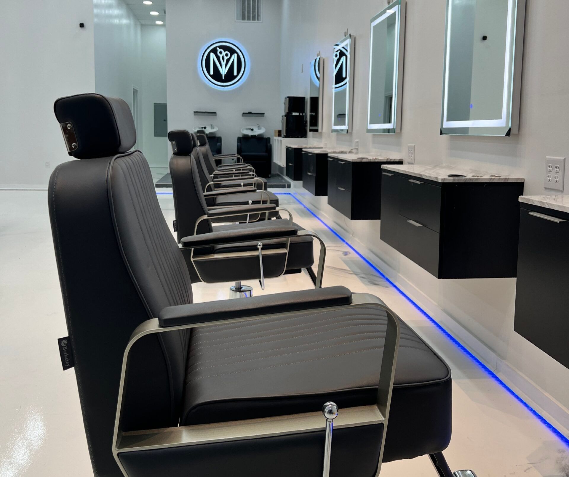 A row of black chairs in a barber shop