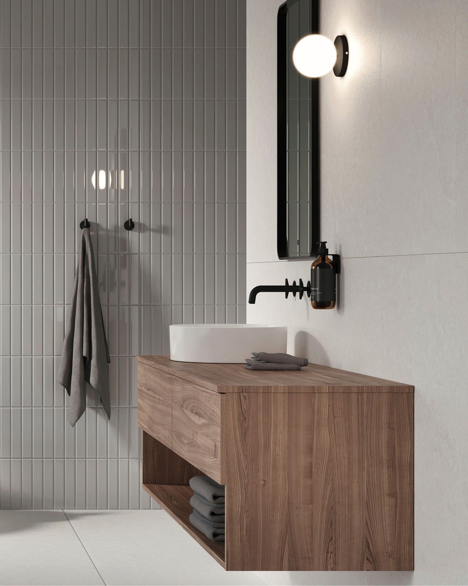 Salle de bain moderne avec vanité en bois, lavabo blanc, luminaires noirs et mur carrelé vertical.