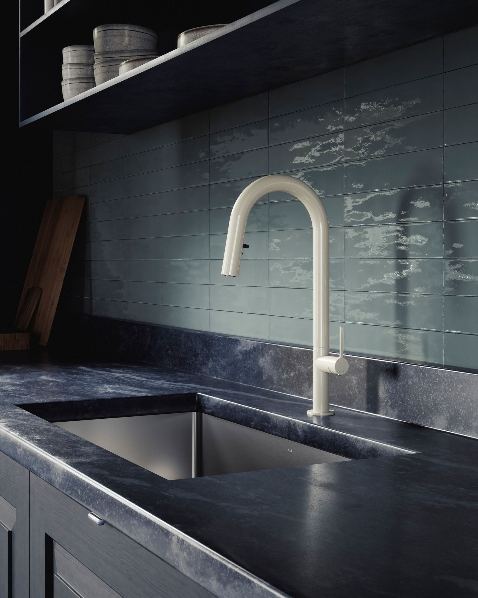 Évier de cuisine avec robinet blanc, comptoirs foncés et dosseret bleu sarcelle.