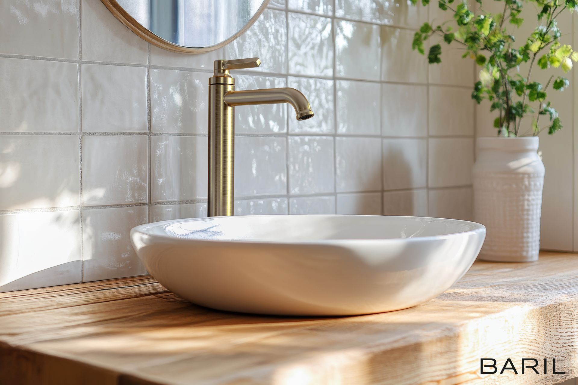 Évier blanc sur un comptoir en bois avec robinet doré, mur carrelé blanc et plante dans un vase.