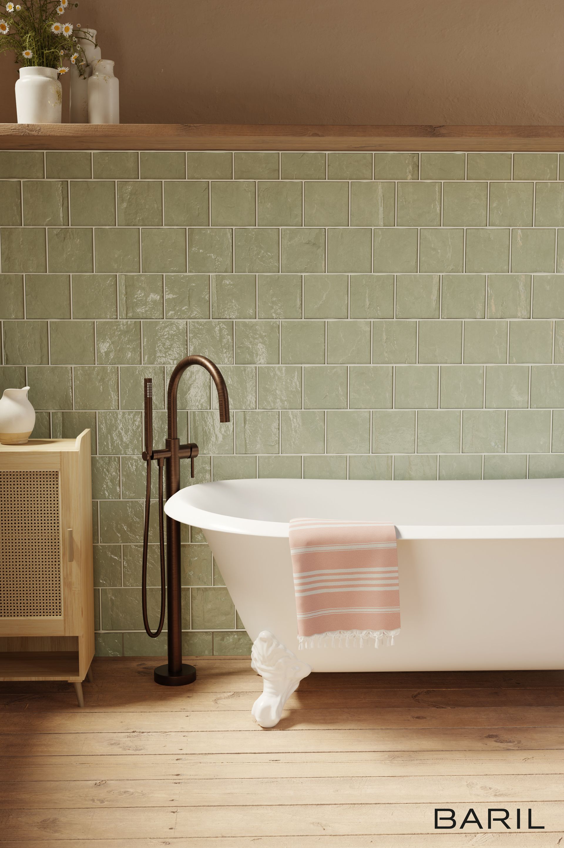 Baignoire autoportante blanche avec robinet en bronze contre mur carrelé vert, plancher en bois.