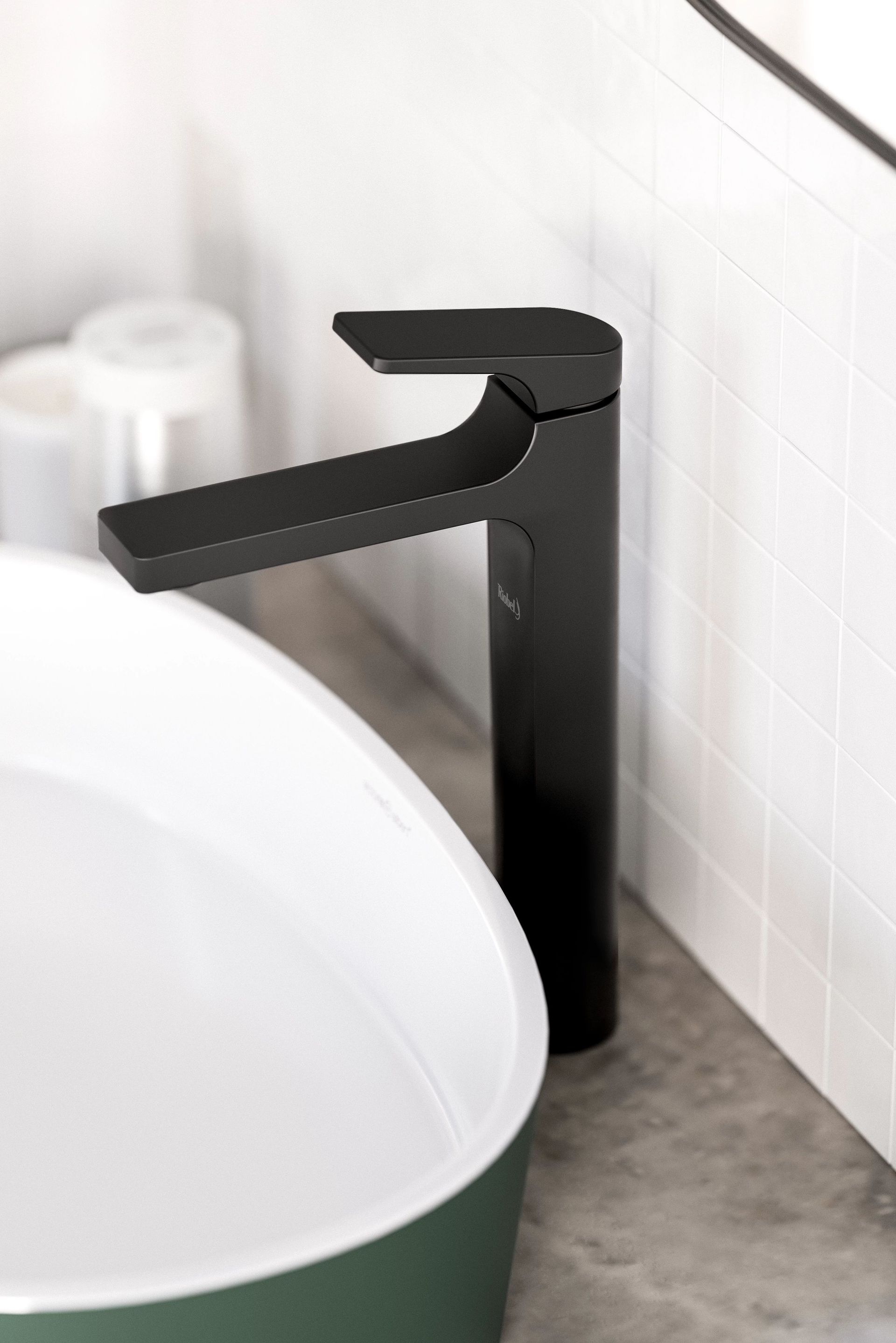 Robinet noir à côté d'un évier blanc et vert contre un mur carrelé.