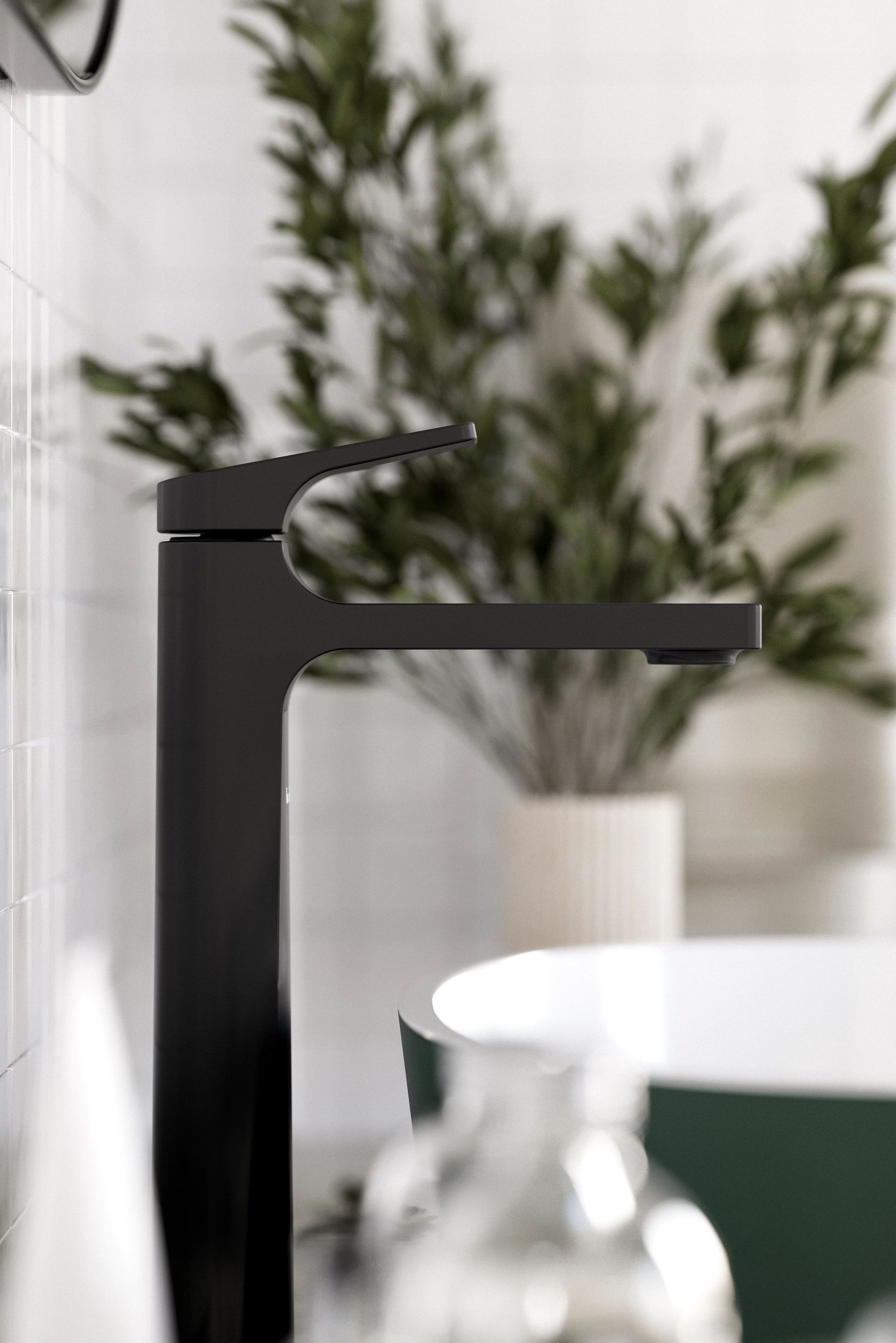 Robinet noir dans une salle de bain moderne avec verdure floue et lavabo en arrière-plan.