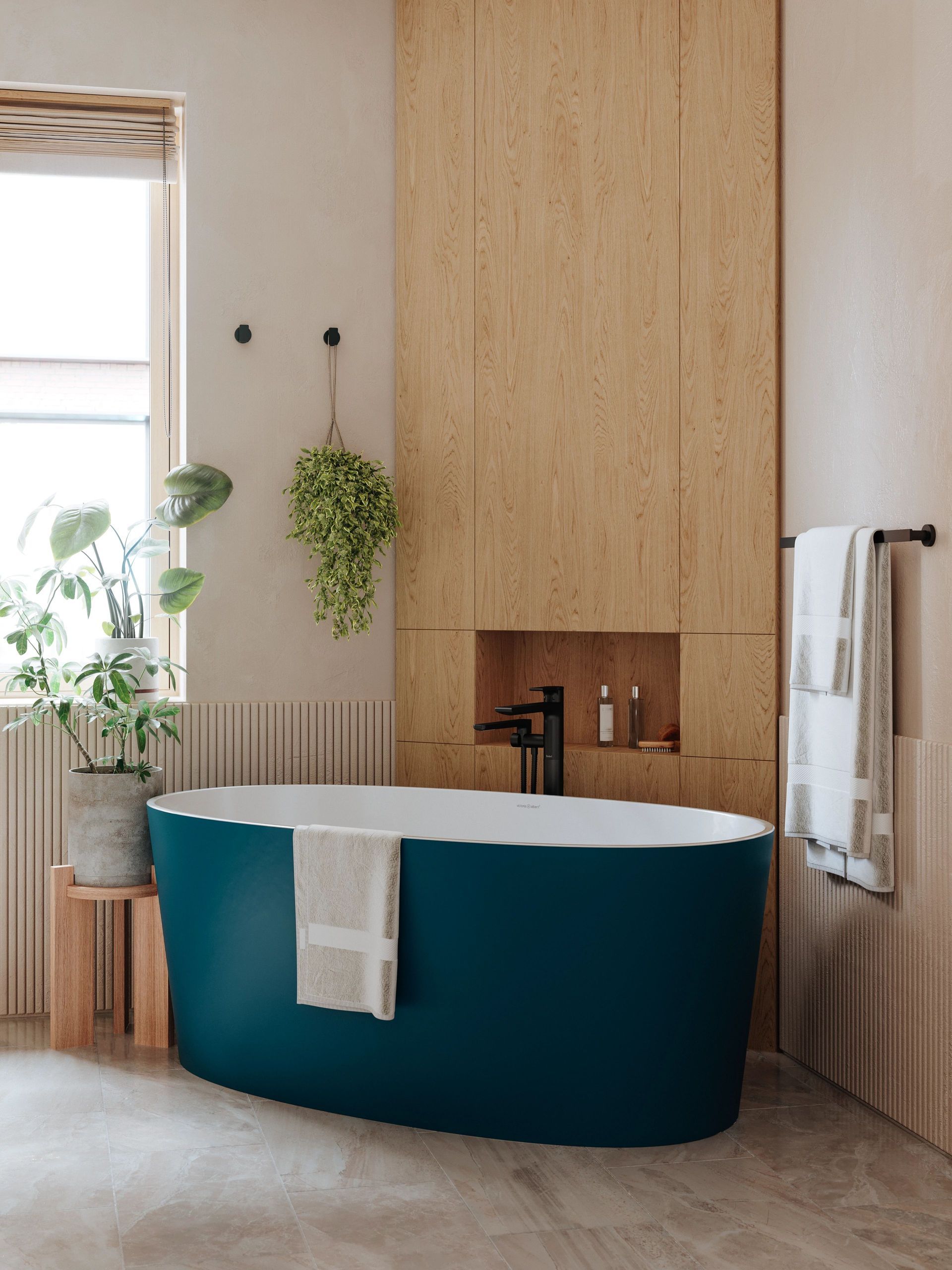 Une baignoire bleu sarcelle dans une salle de bain minimaliste avec des accents en bois et une fenêtre.