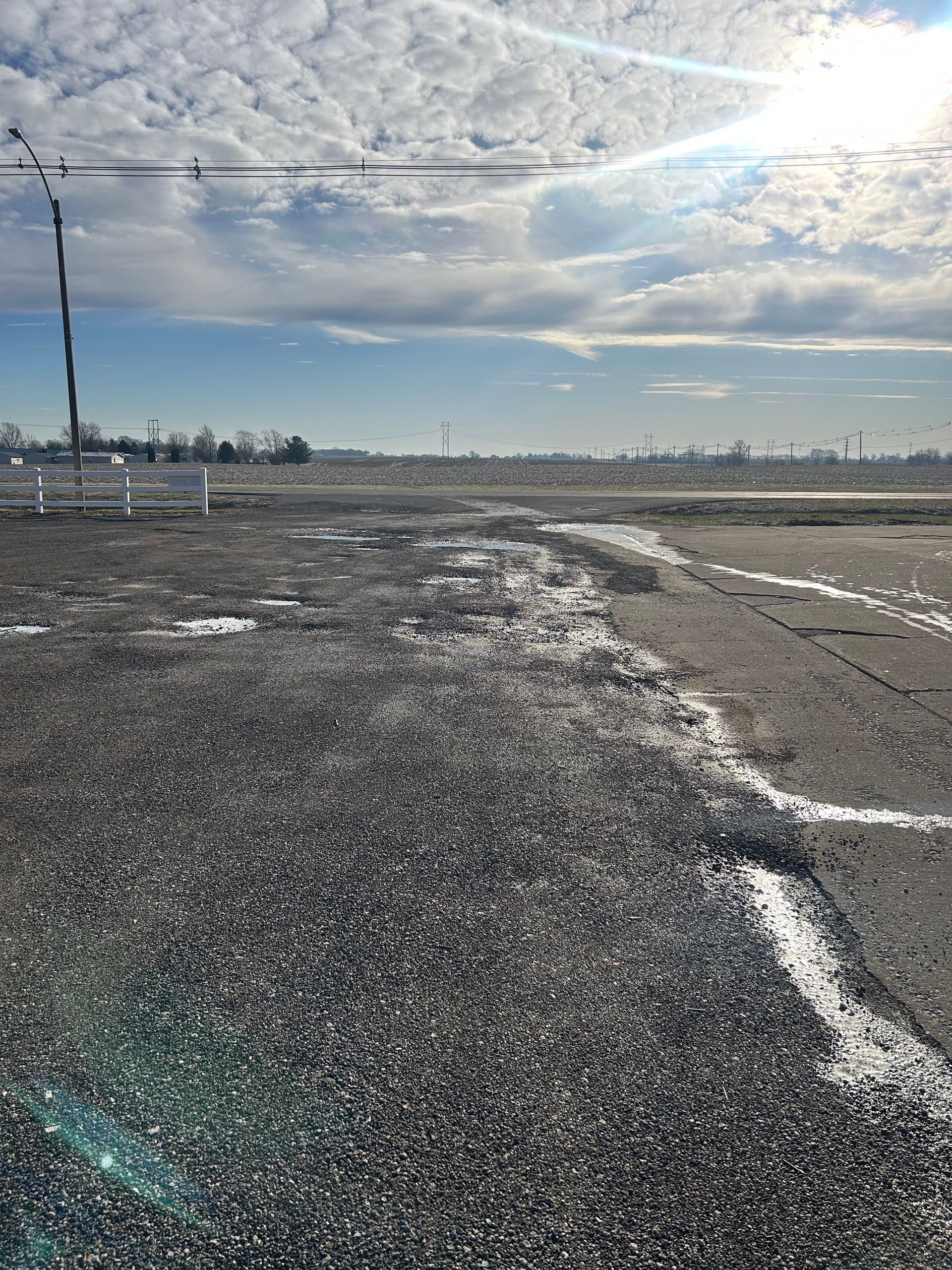 A gray asphalt road with a white line on the side of it.