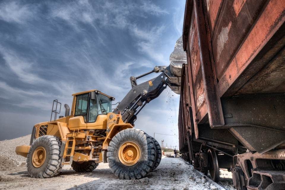 a bulldozer filling the truck with the material