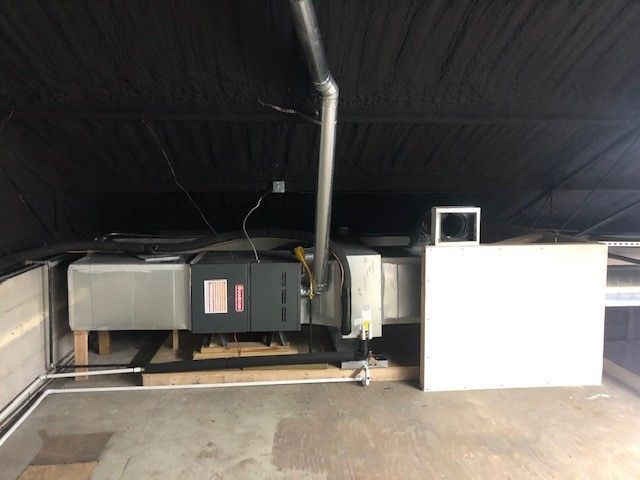 An air conditioner is hanging from the ceiling of a building.