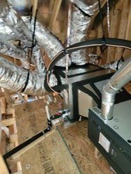 There are a lot of ducts hanging from the ceiling in this room.