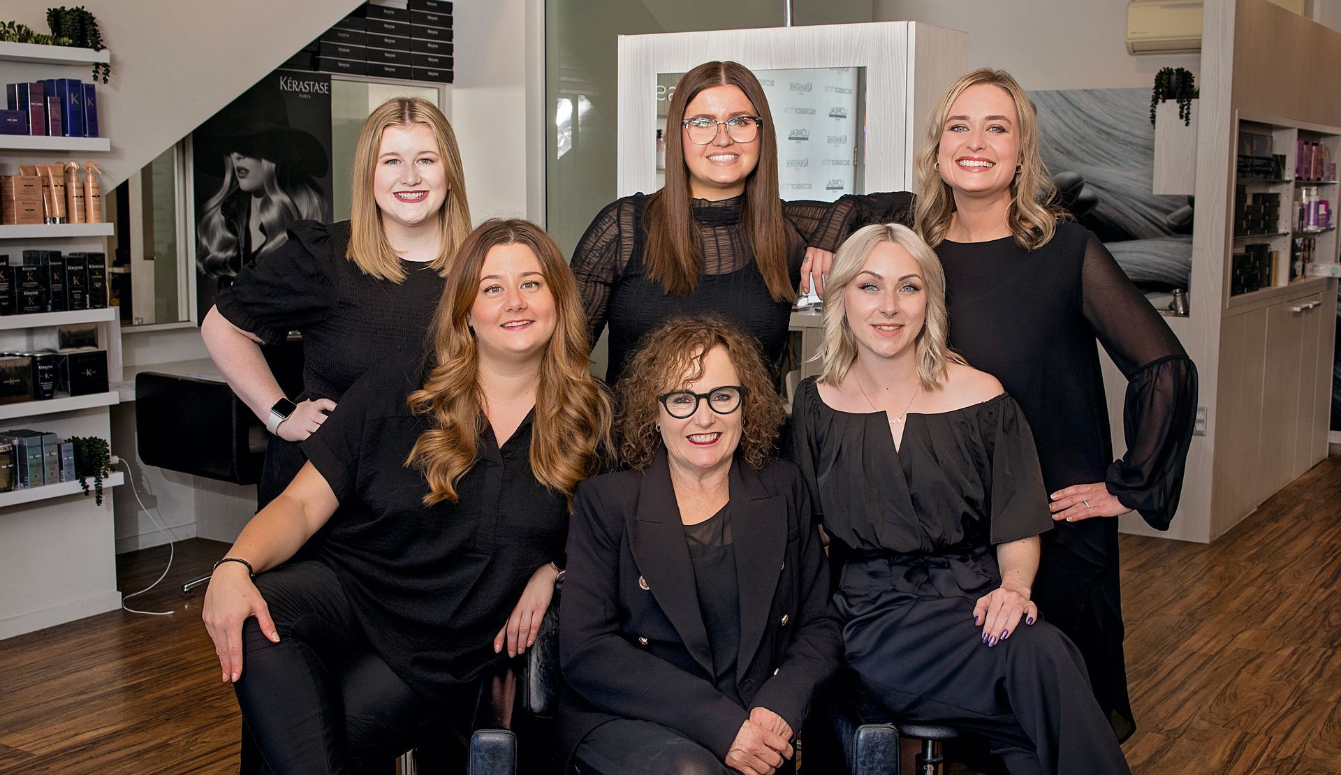 A group of women are posing for a picture in a salon.