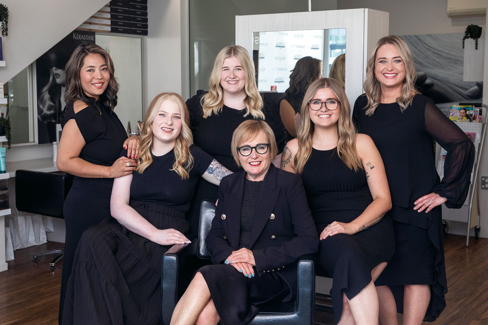 A group of women are posing for a picture in a salon.