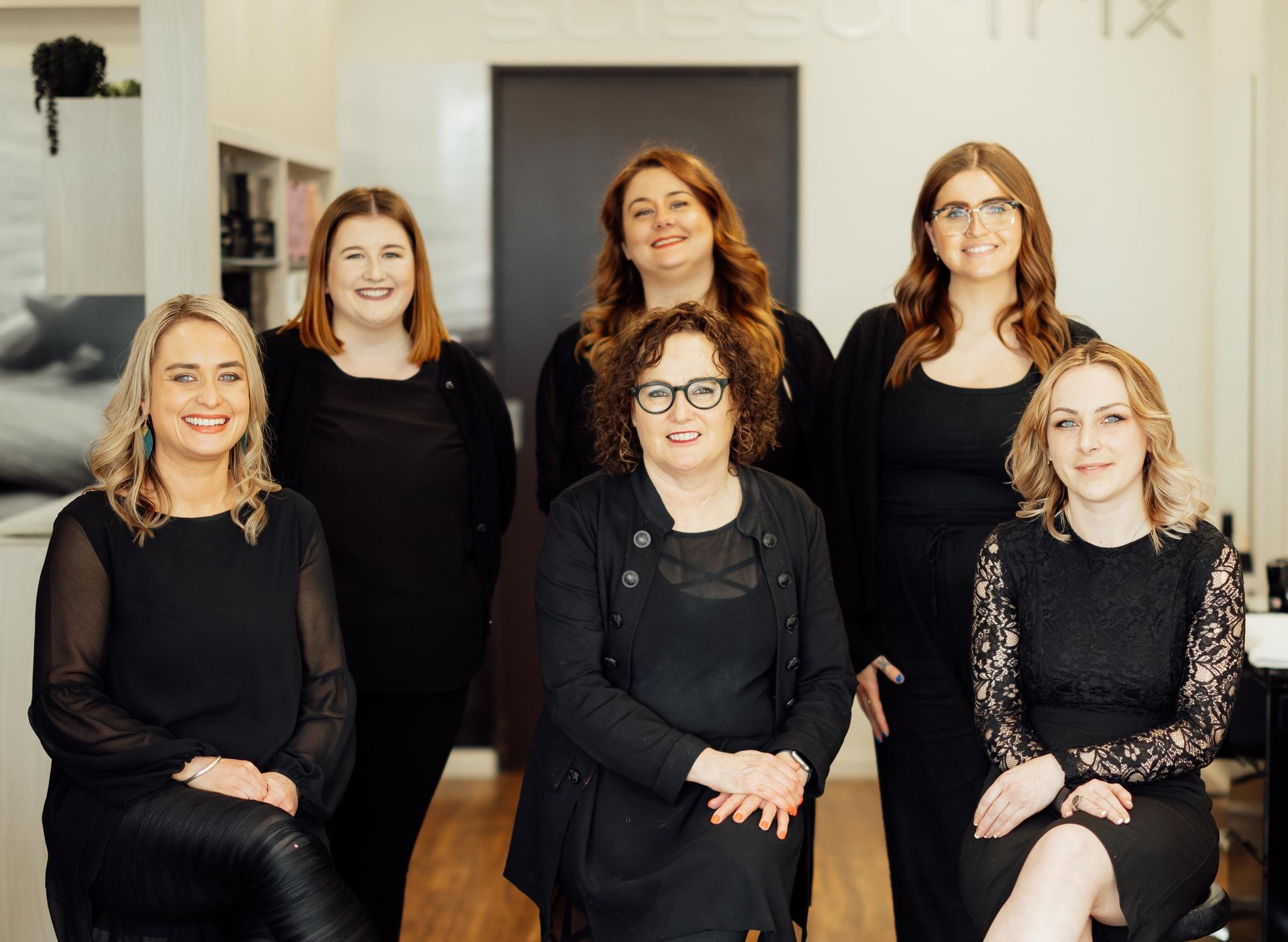 A group of women are posing for a picture in a salon.