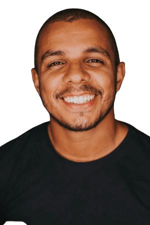 Smiling Black man with shaved head in a black shirt.