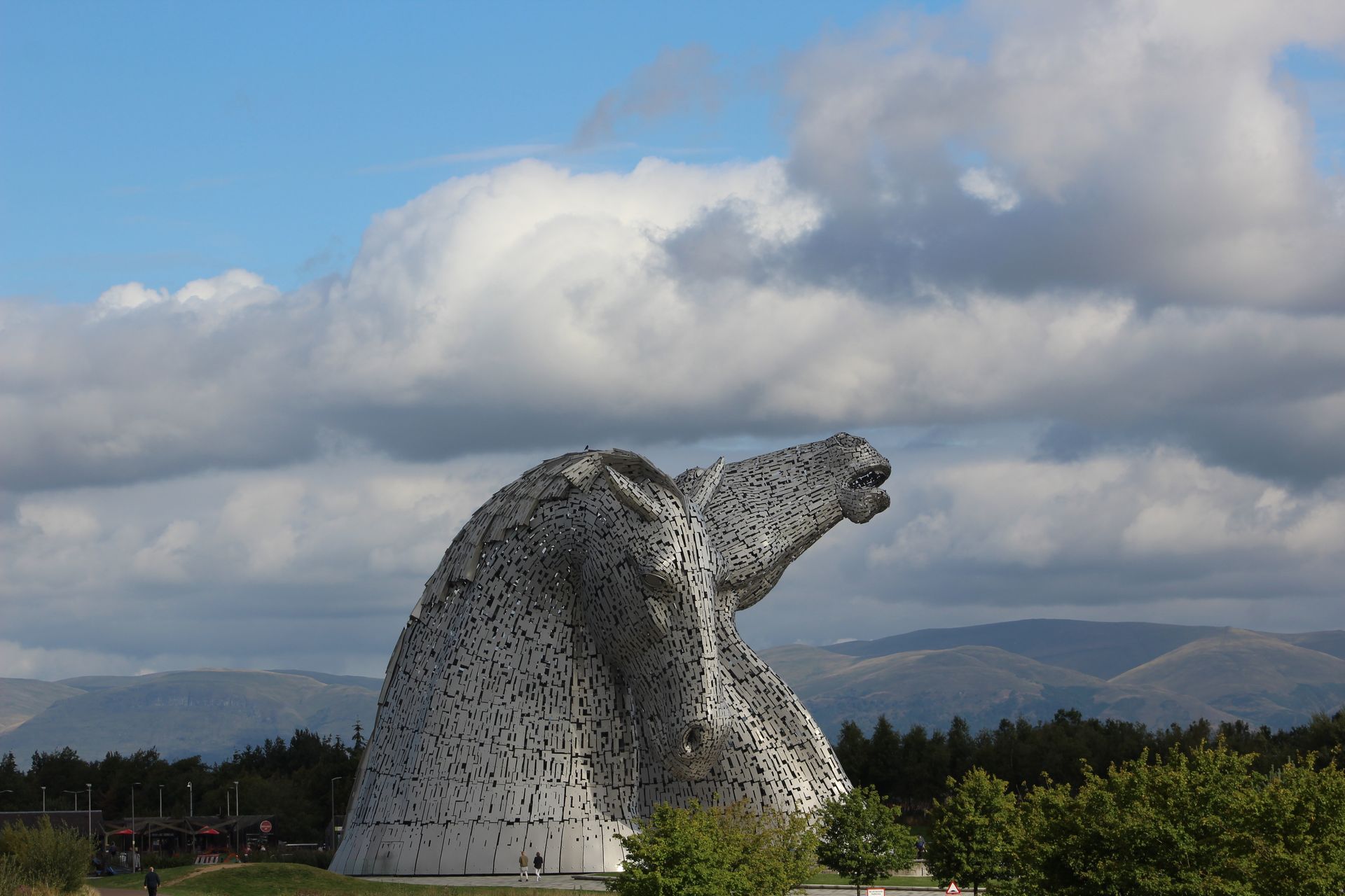A large statue of a horse 's head with mountains in the background.