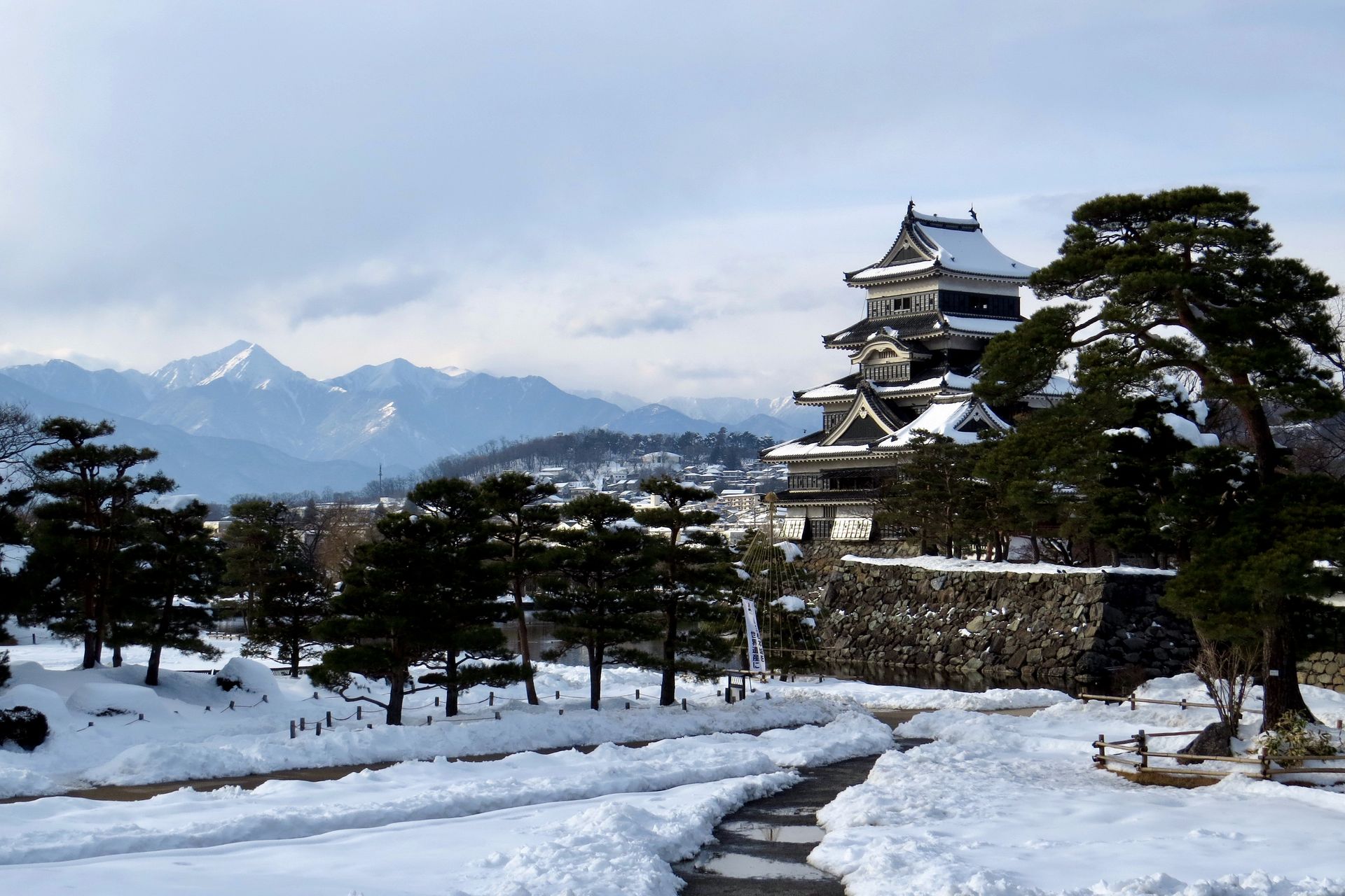 A snowy park with a castle in the background