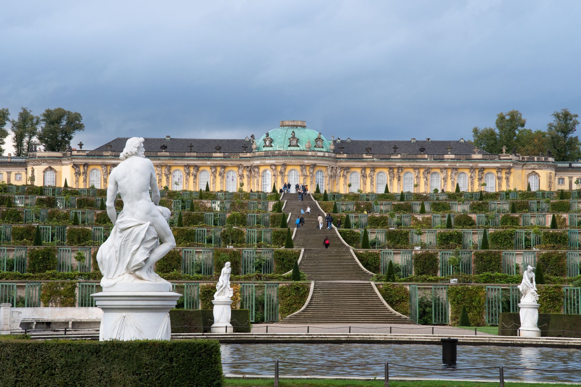 A large building with stairs leading up to it and a statue in front of it