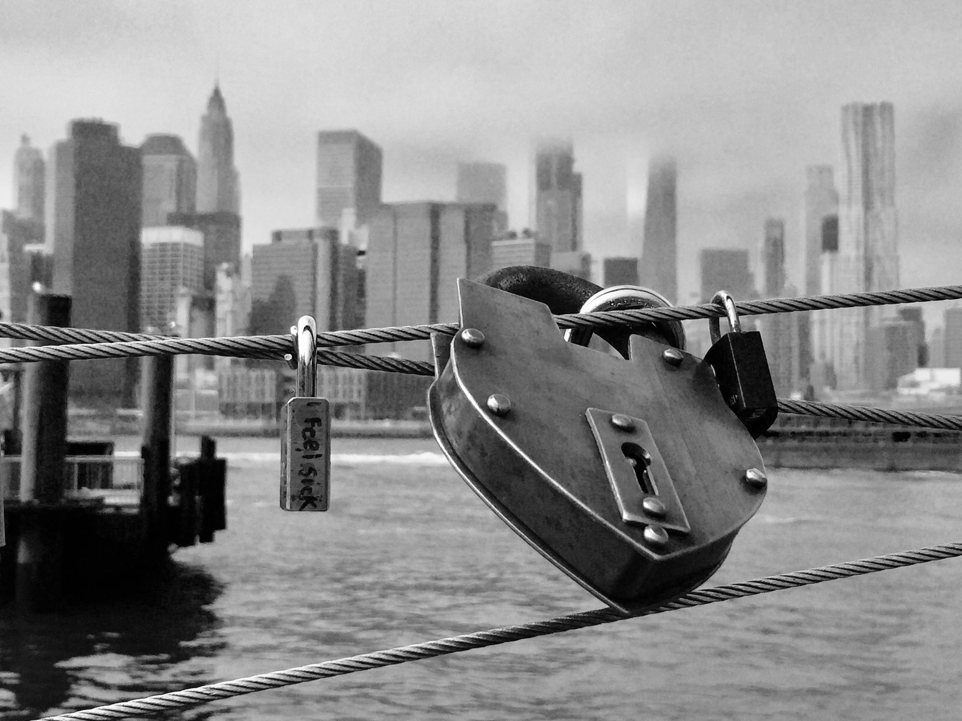 A black and white photo of a bridge with a padlock on it