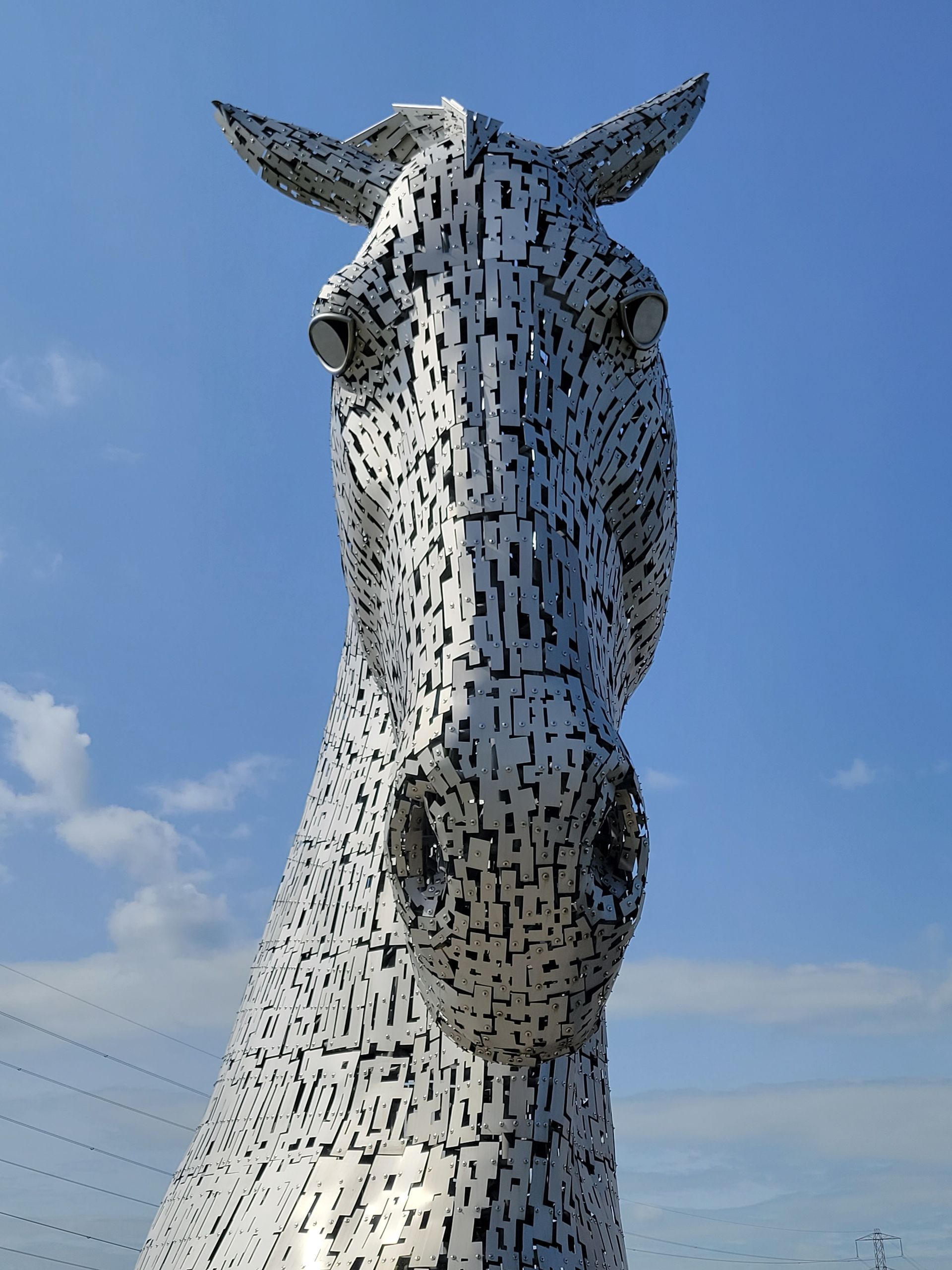 A statue of a horse with a blue sky in the background