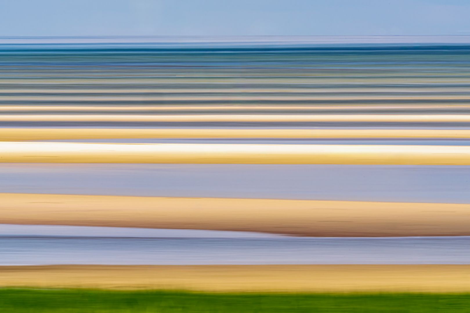 A blurry picture of a beach with a blue sky in the background.