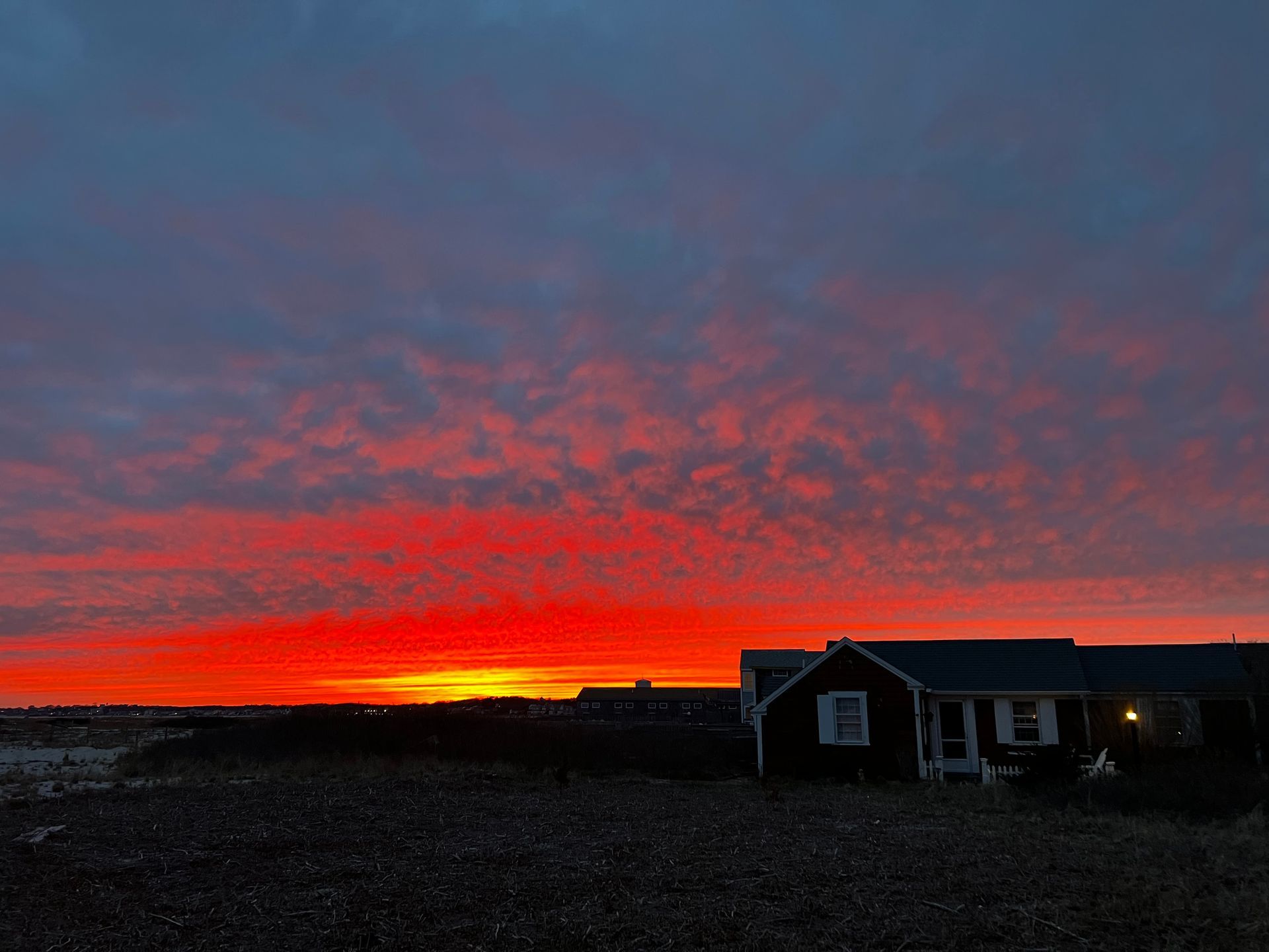 there is a house in the foreground and a sunset in the background .