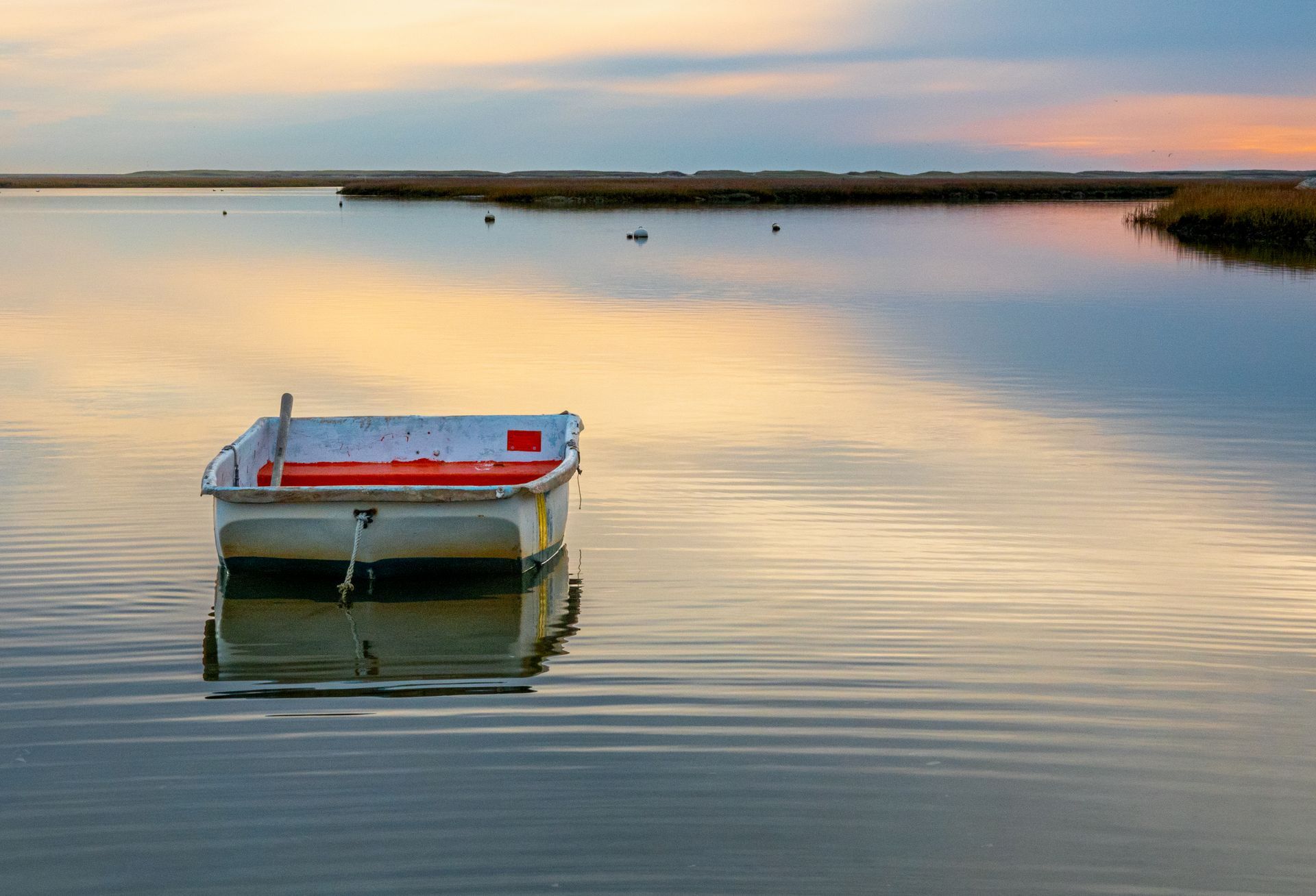a small boat is floating on top of a body of water .