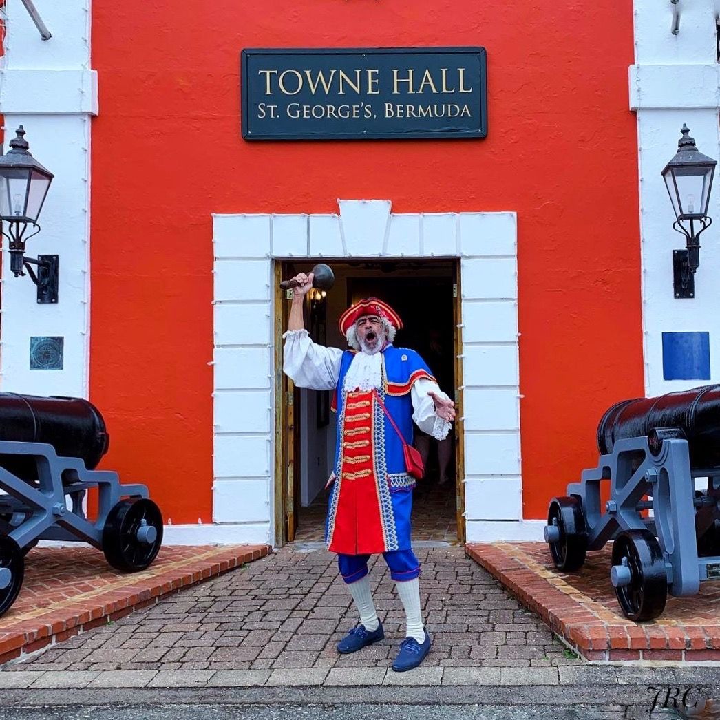 A man in a costume is standing in front of the town hall