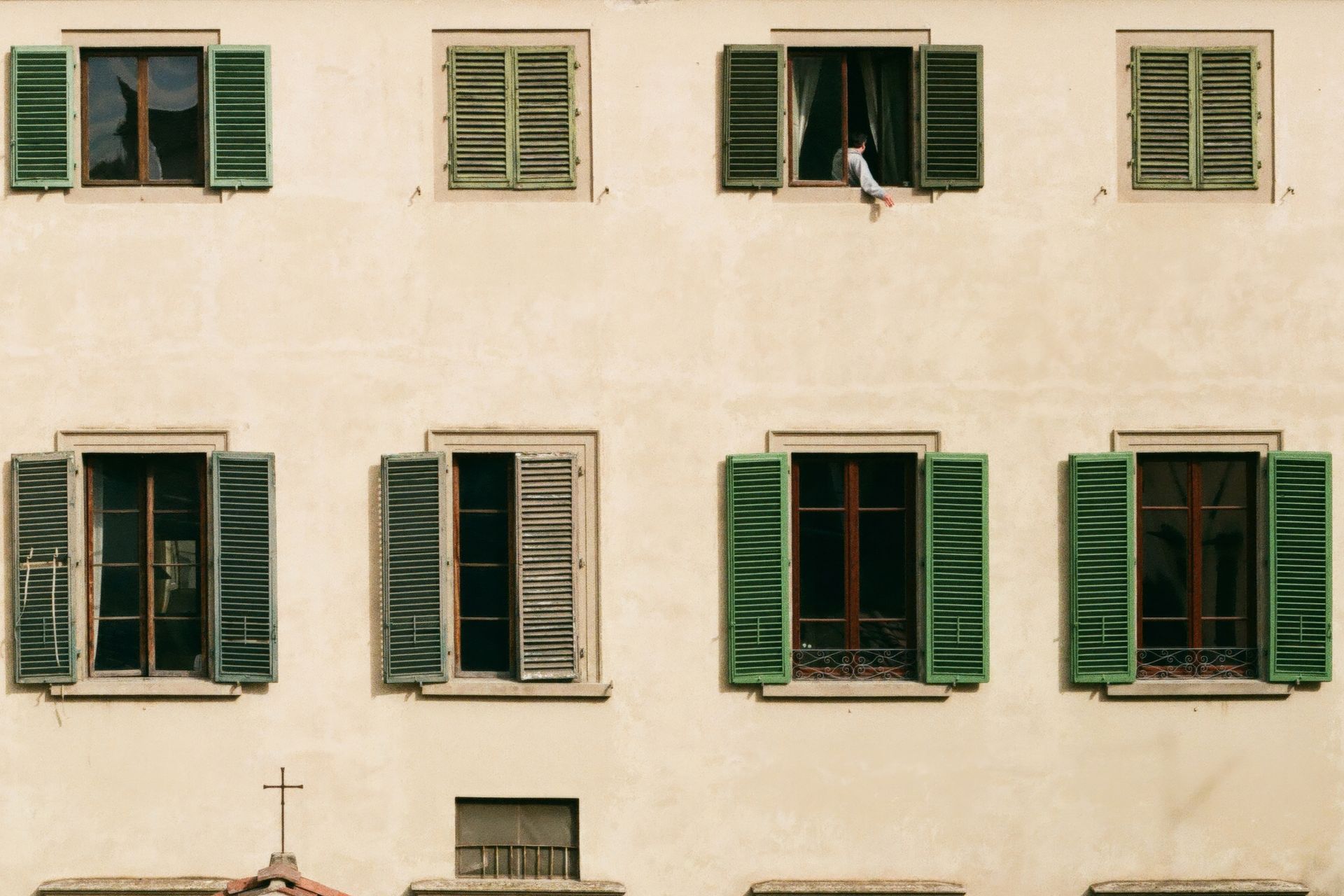 A building with lots of windows and green shutters