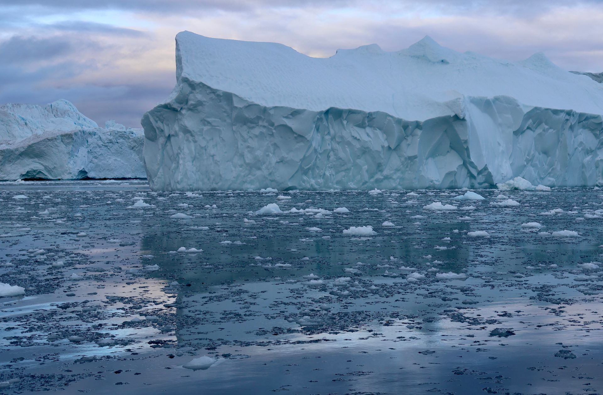 A large iceberg is floating on top of a body of water.
