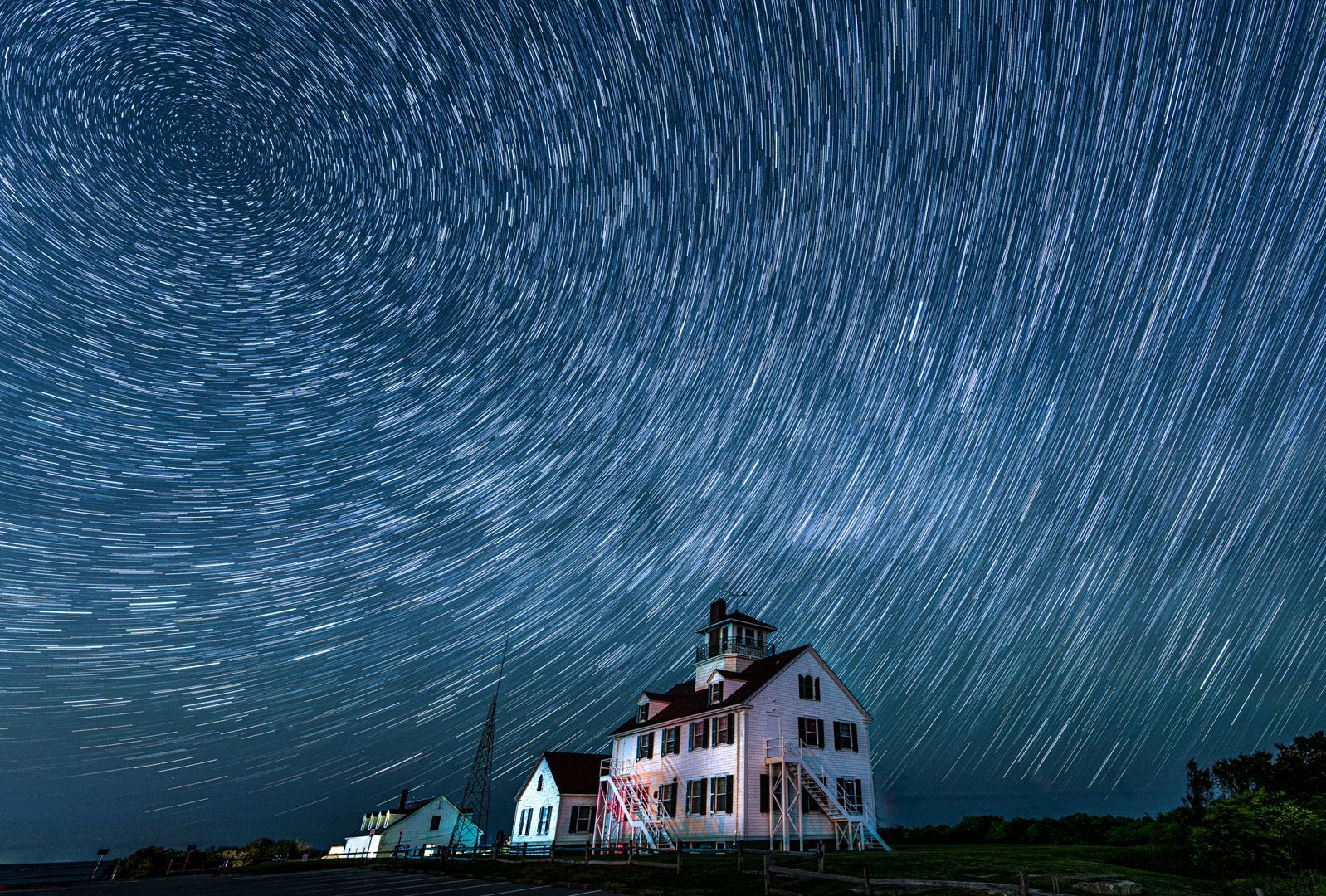 A house is lit up at night under a starry sky.