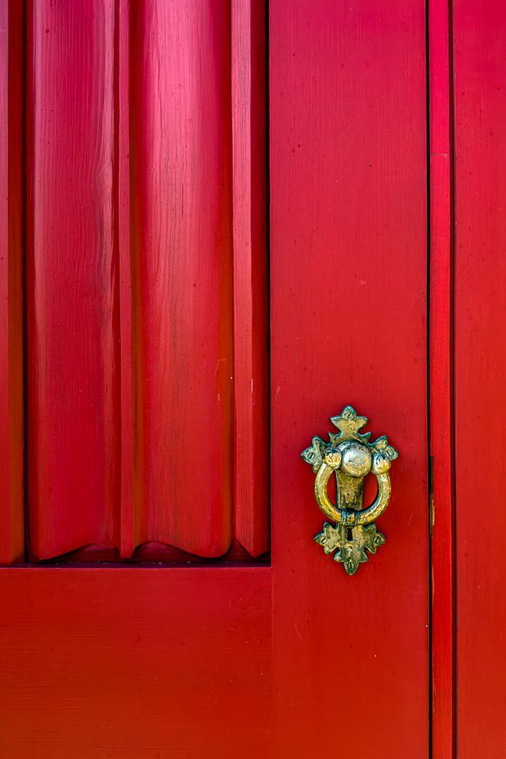 A red door with a gold door knocker on it.