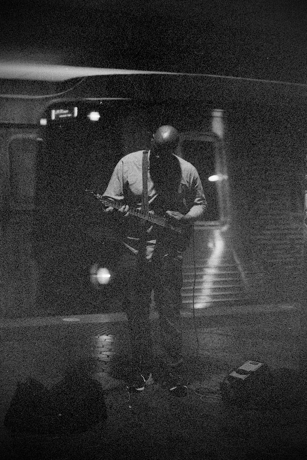 A man is playing a guitar in a black and white photo.