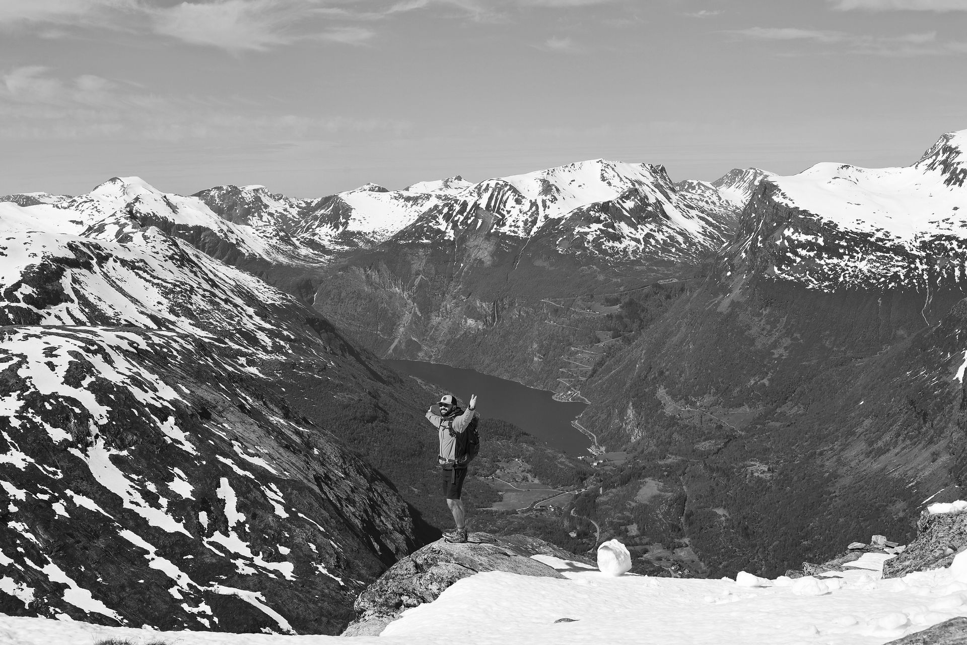 A black and white photo of a person standing on top of a snowy mountain